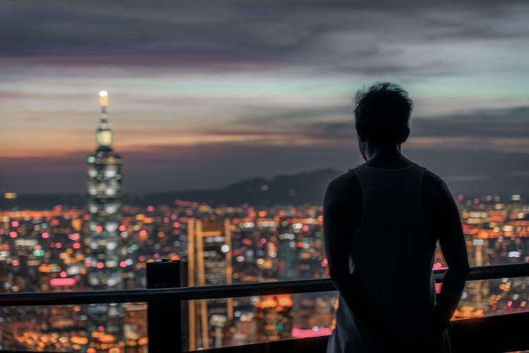 Silhouette Of Man On Balcony In City