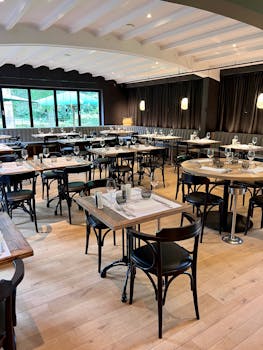 Chic restaurant interior with arranged tables and stylish lighting, offering a cozy dining atmosphere.