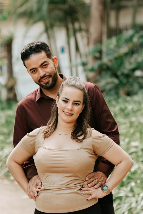 Free Smiling couple posing in a lush tropical garden, exuding warmth and love. Stock Photo