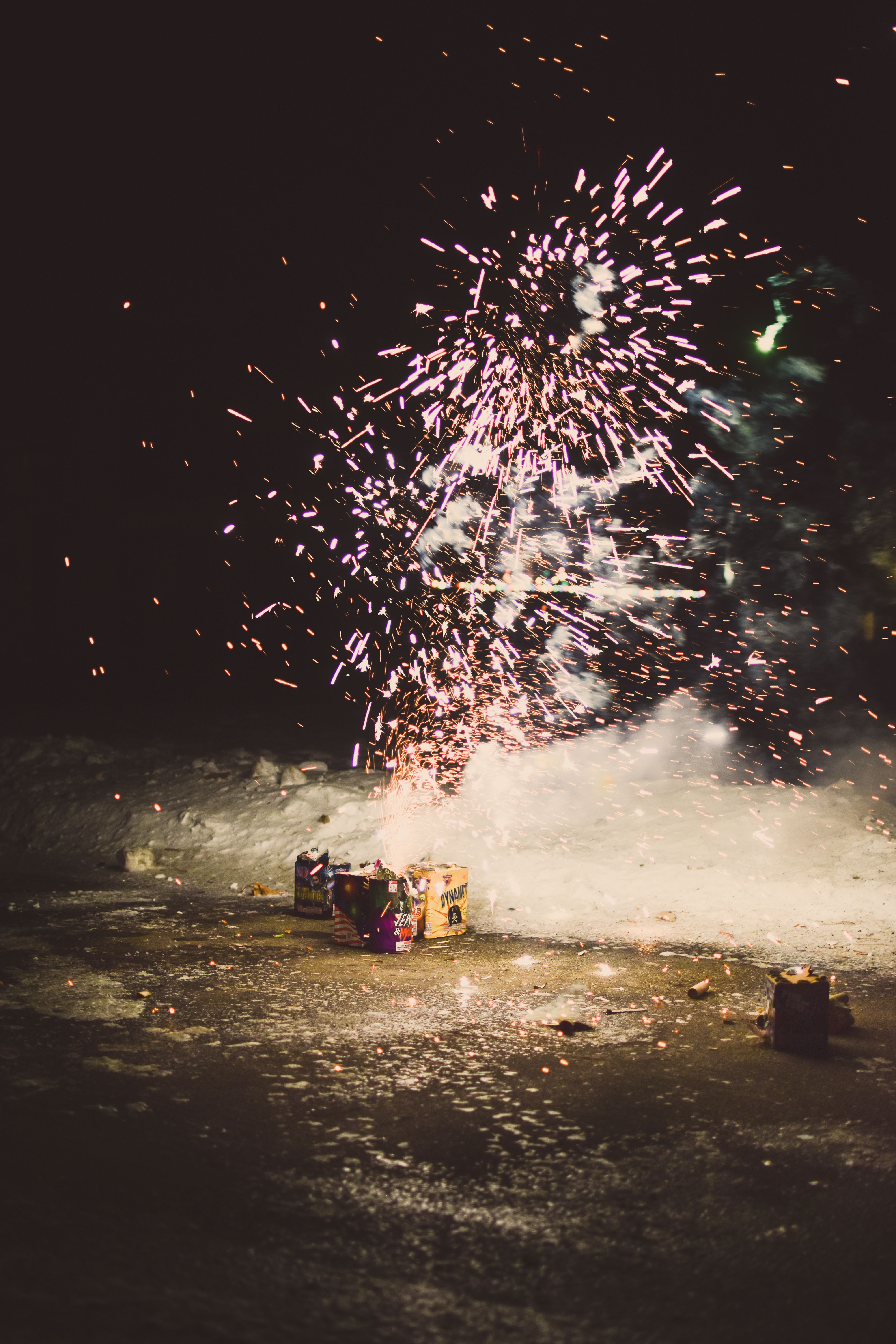 Spectacular nighttime fireworks display with bright sparks and smoke, perfect for celebrations.