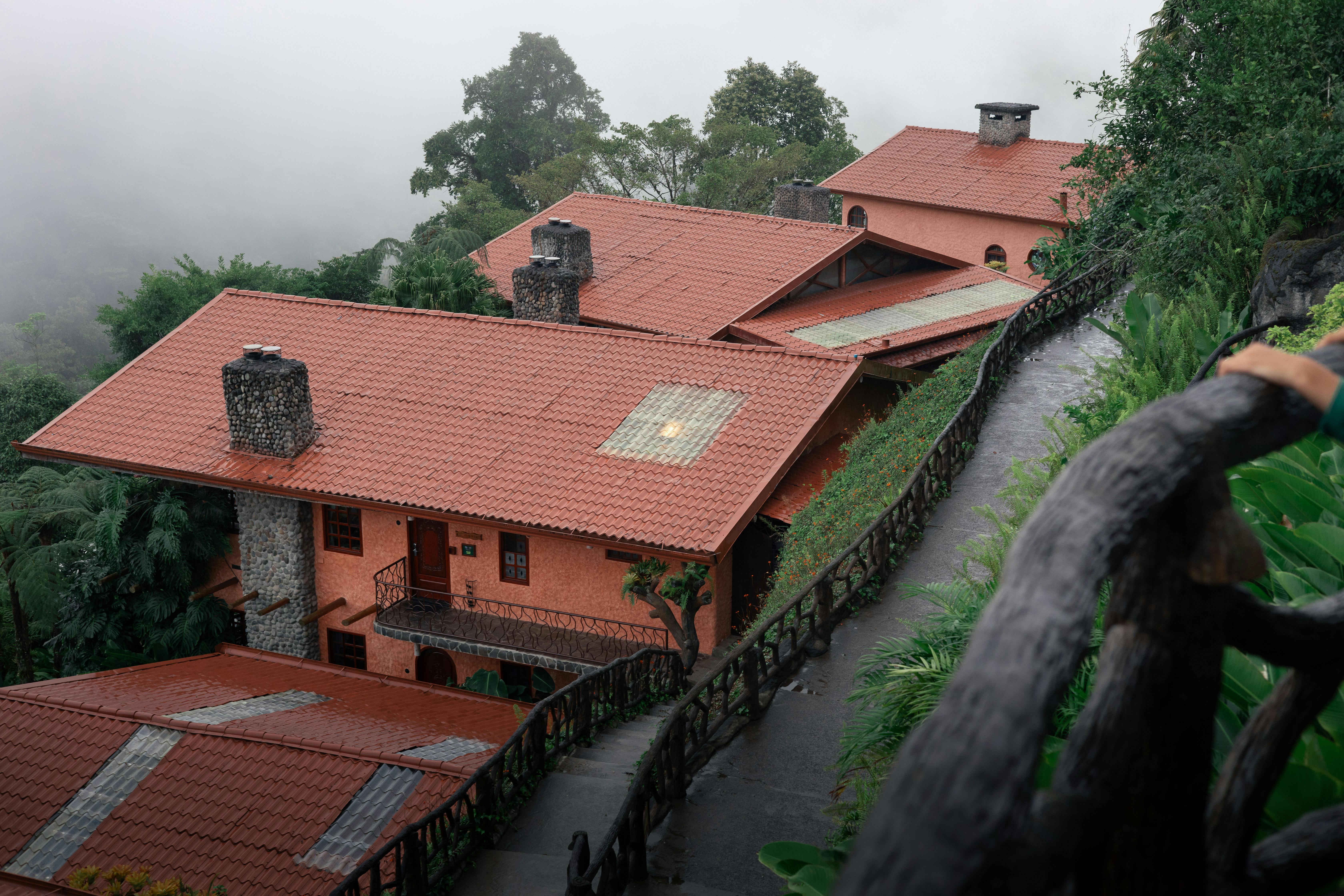 a house on a hillside with a red roof