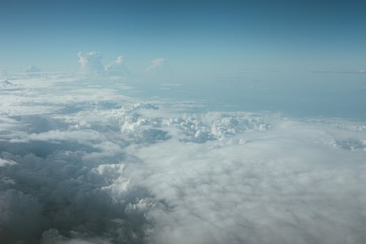 Peaceful aerial view of fluffy clouds and blue sky, showcasing natural serenity and beauty.