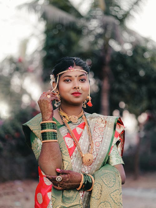 Photo of a Woman Wearing Green and Orange Decorative Traditional Clothing