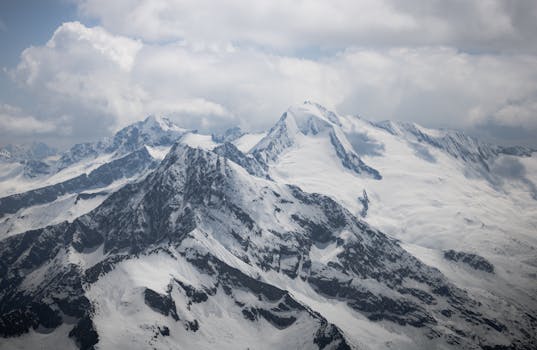 Breathtaking view of snow-clad mountains in Hintertux, Austria under cloudy skies.