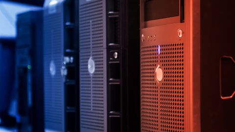 Close-up of tower servers in a data center with blue and red lighting.