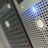 Close-up of a modern computer server rack featuring glowing blue LED indicator lights in a data center.