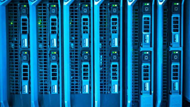 Server rack illuminated in blue inside a data centre