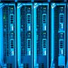 Rows of illuminated servers in a dark, modern data center.