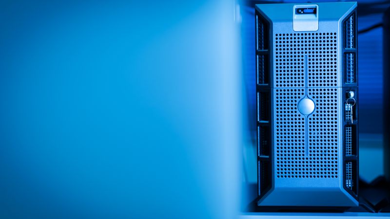 Close-up of a modern server unit in a blue-lit data center environment.