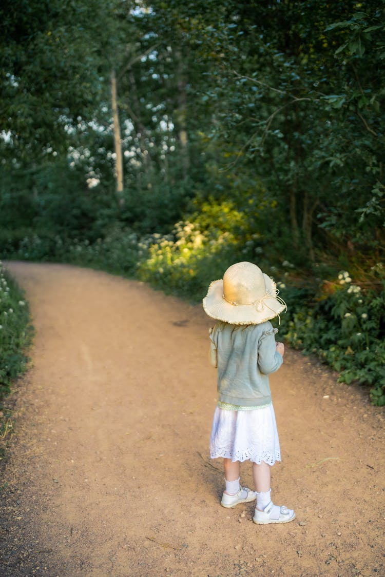 Girl In Hat On Footpath In Forest