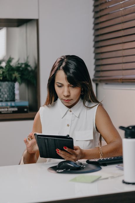 Developer reviewing a build on a tablet at her desk — photo by Sandro Tavares on Pexels
