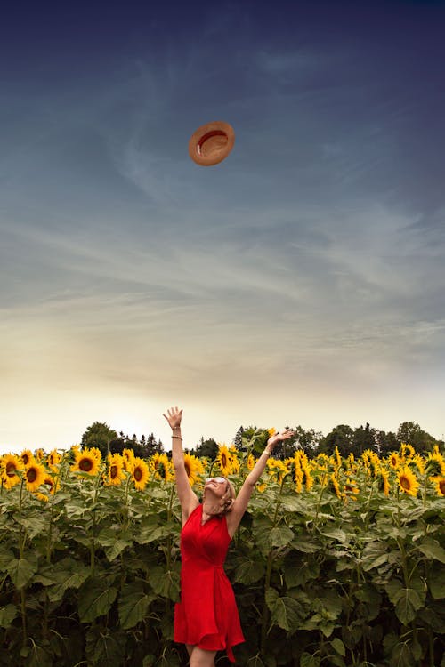 Free Photo of Woman Throwing Her Straw Hat Upwards Stock Photo