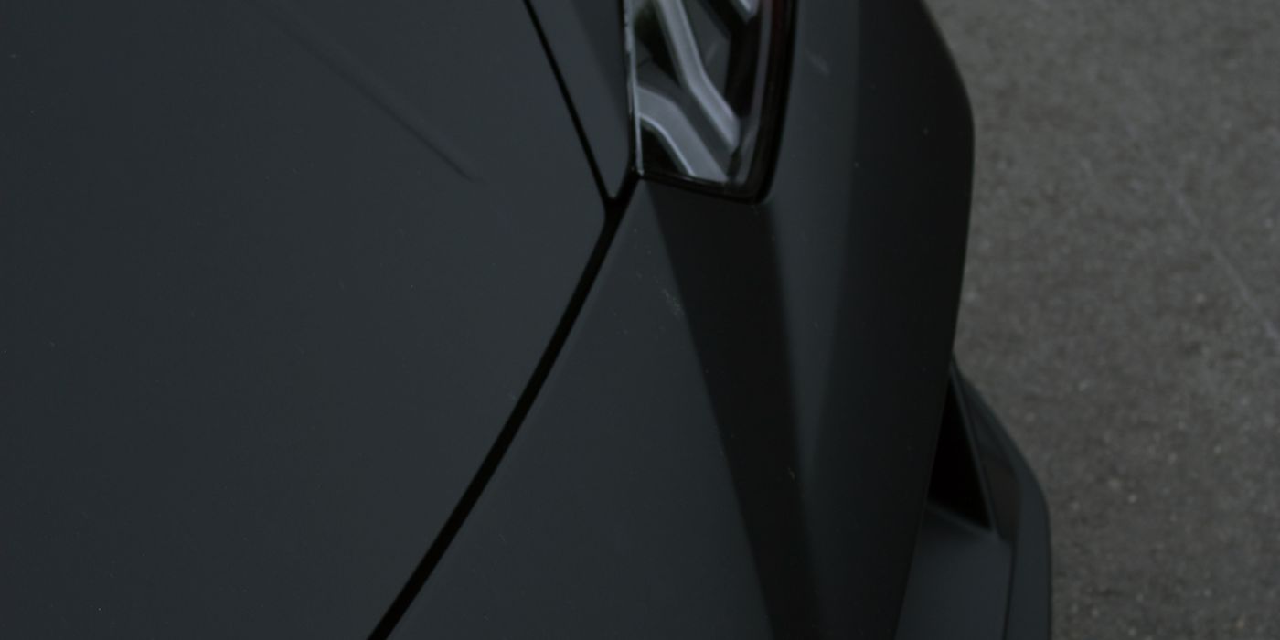 Close-up of the nose of a matte black Lamborghini