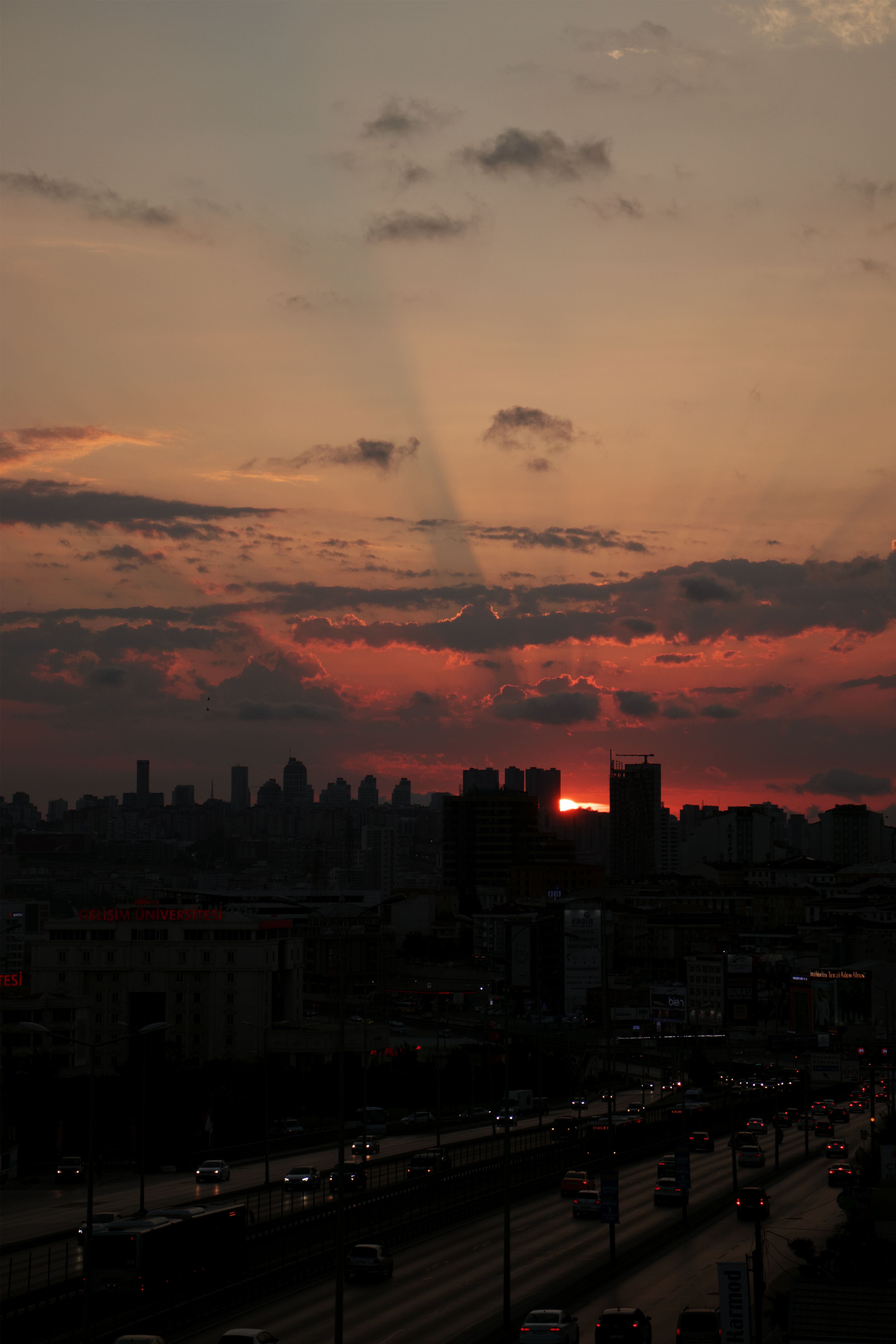 A dramatic İstanbul cityscape at dusk featuring a vibrant sunset and urban skyline silhouette.