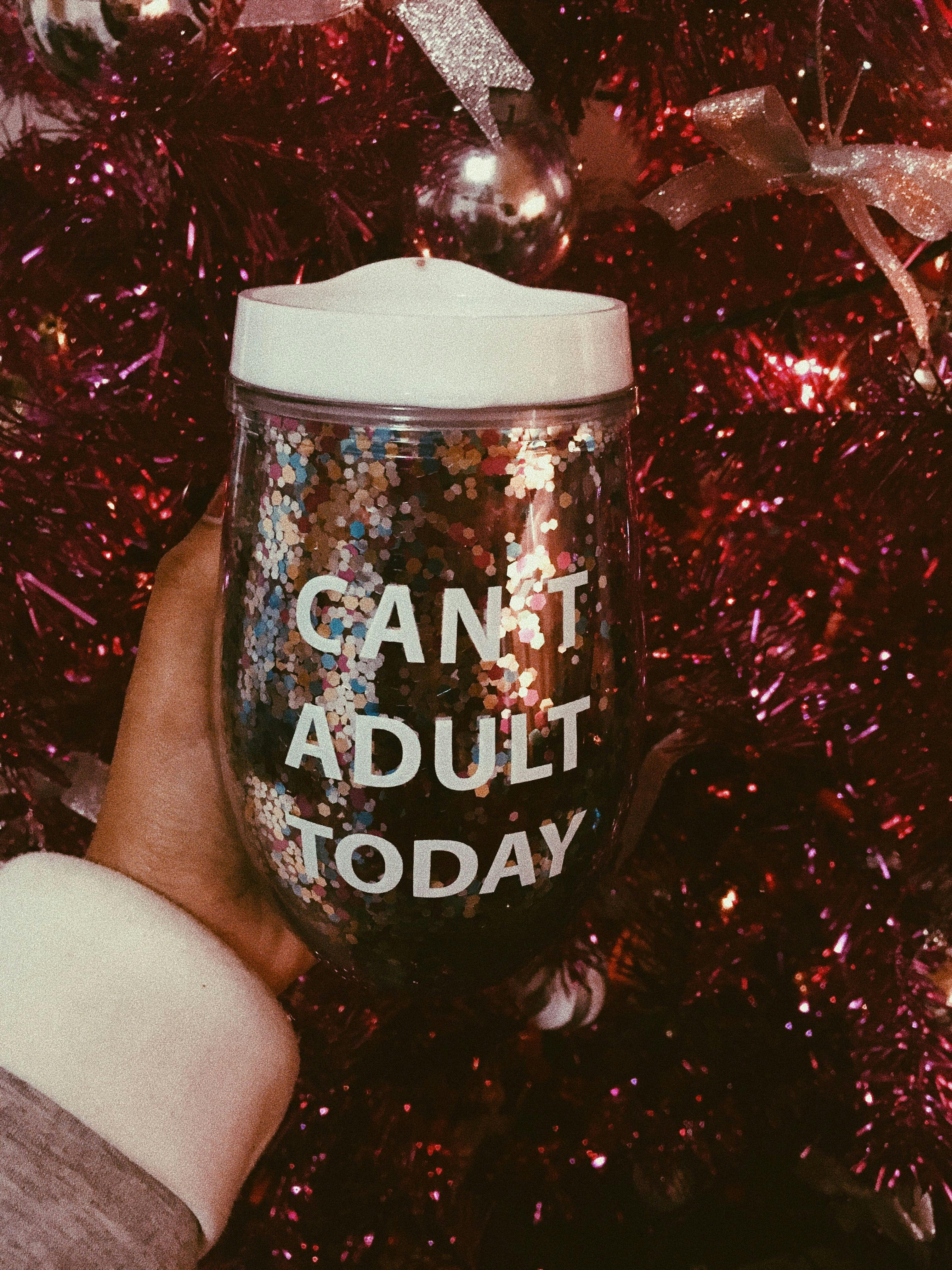 闪闪发光的杯子上印着幽默的文字，搭配着充满活力的圣诞树装饰