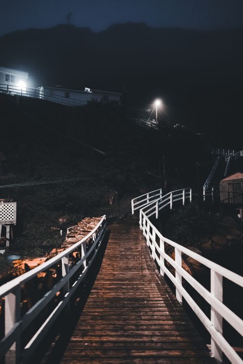 Free A dimly lit wooden bridge at night, offering a serene and mysterious ambiance. Stock Photo