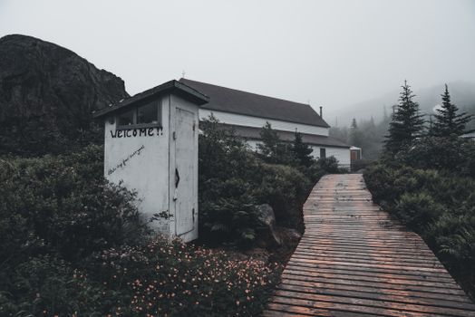 A Boardwalk Between an Outhouse and a House 