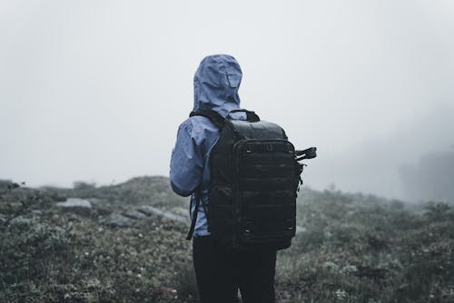 Back View of a Woman Wearing Hooded Jacket and a Backpack 