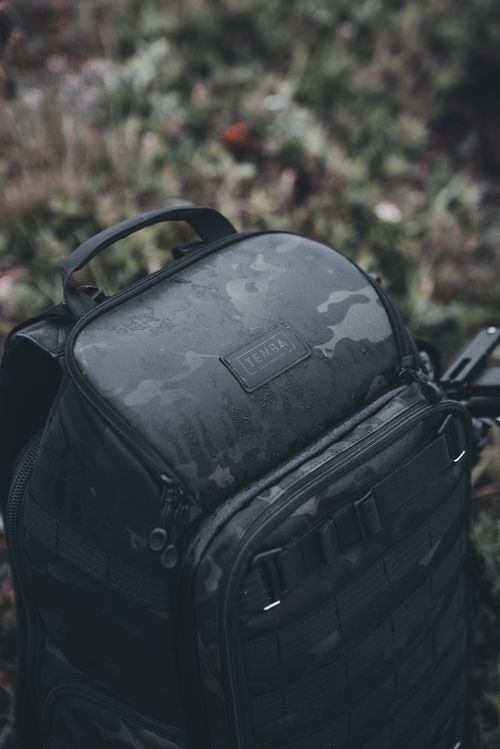 Free Close-up of a Tenba camouflage backpack outdoors, showcasing rugged design. Stock Photo