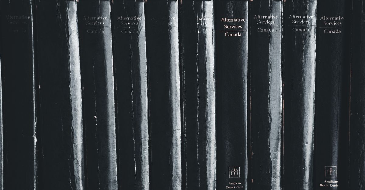 Close-up of black books on a shelf highlighting their titles.