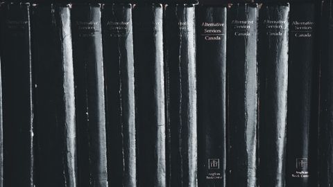 Close-up of black books on a shelf highlighting their titles.