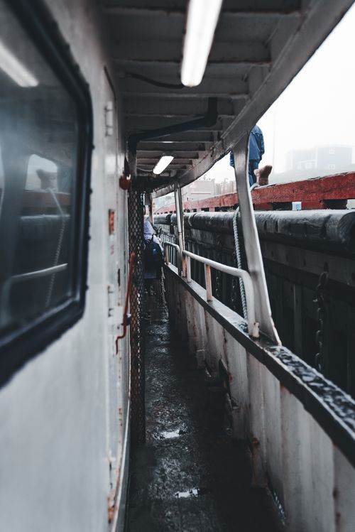 Free Side view of a narrow boat passageway with passengers on board, emphasizing travel and transit. Stock Photo