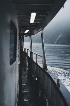 Atmospheric view of a boat railing on a foggy sea journey creating a mysterious ambiance.