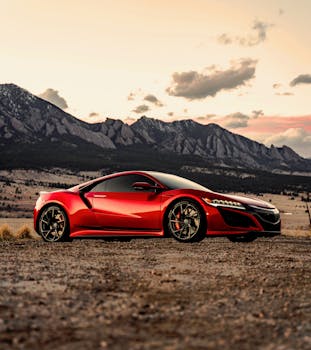 Stunning red supercar parked against Denver's mountainous landscape at sunset.