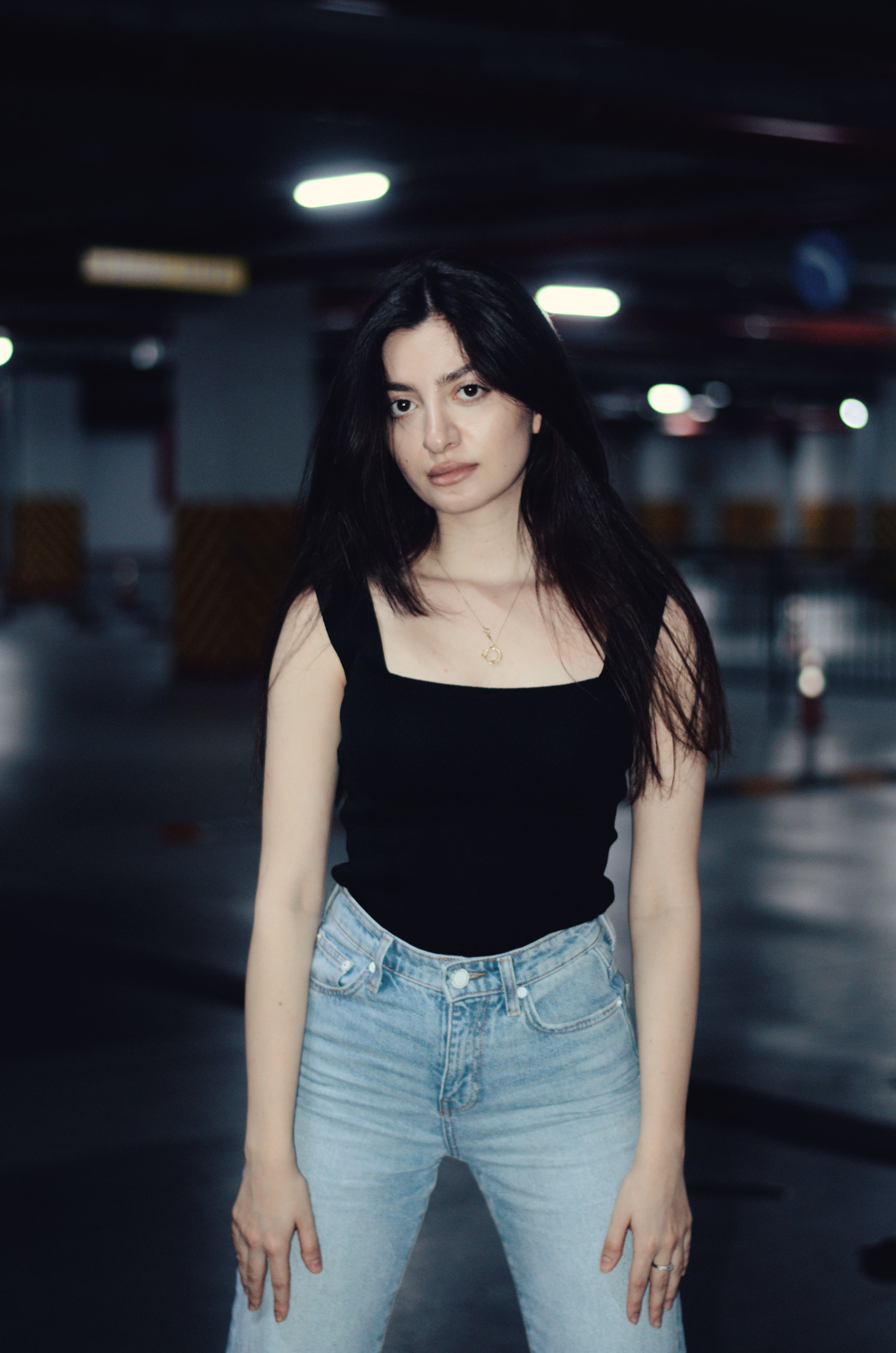 Fashionable woman in casual attire posing confidently in an urban environment.