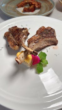Succulent lamb chops paired with vibrant garnishes in a fine dining setting.
