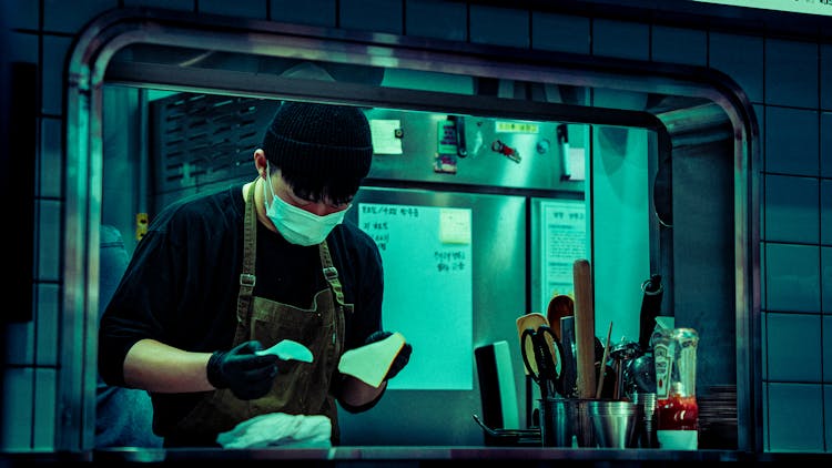 Man In Mask Working At Food Bar