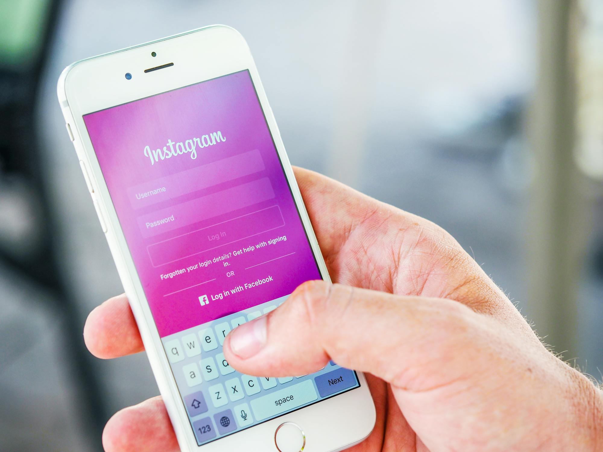 Pros and cons of instagram man holding smartphone with instagram login screen displayed