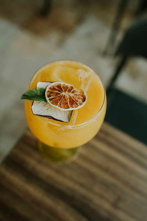 Free Top view of a citrus cocktail with lime and mint garnish on a wooden table. Stock Photo