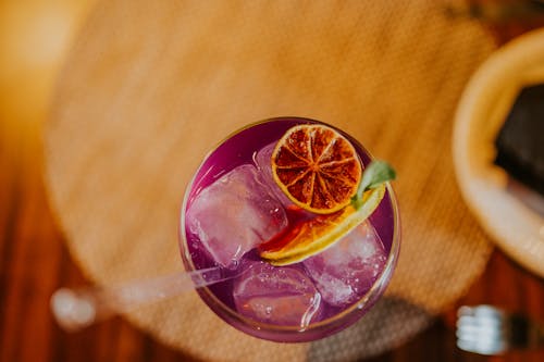 Foto gratis de una bebida morada con una rodaja de naranja encima