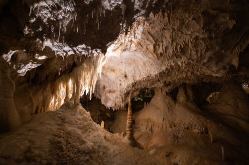 Free Explore the captivating formations of stalactites and stalagmites in this enchanting natural cave. Stock Photo