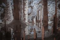 Explore this breathtaking view of stalactites and stalagmites in an underground cave, showcasing natural beauty and geological formations.