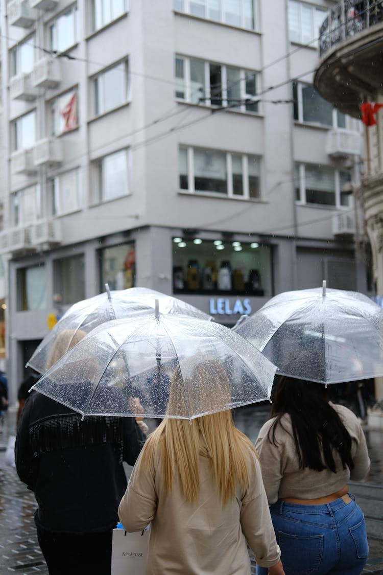 People With Umbrellas On A Street