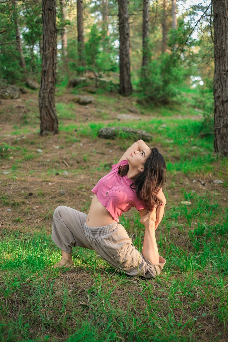 Woman Practicing Yoga Among Trees