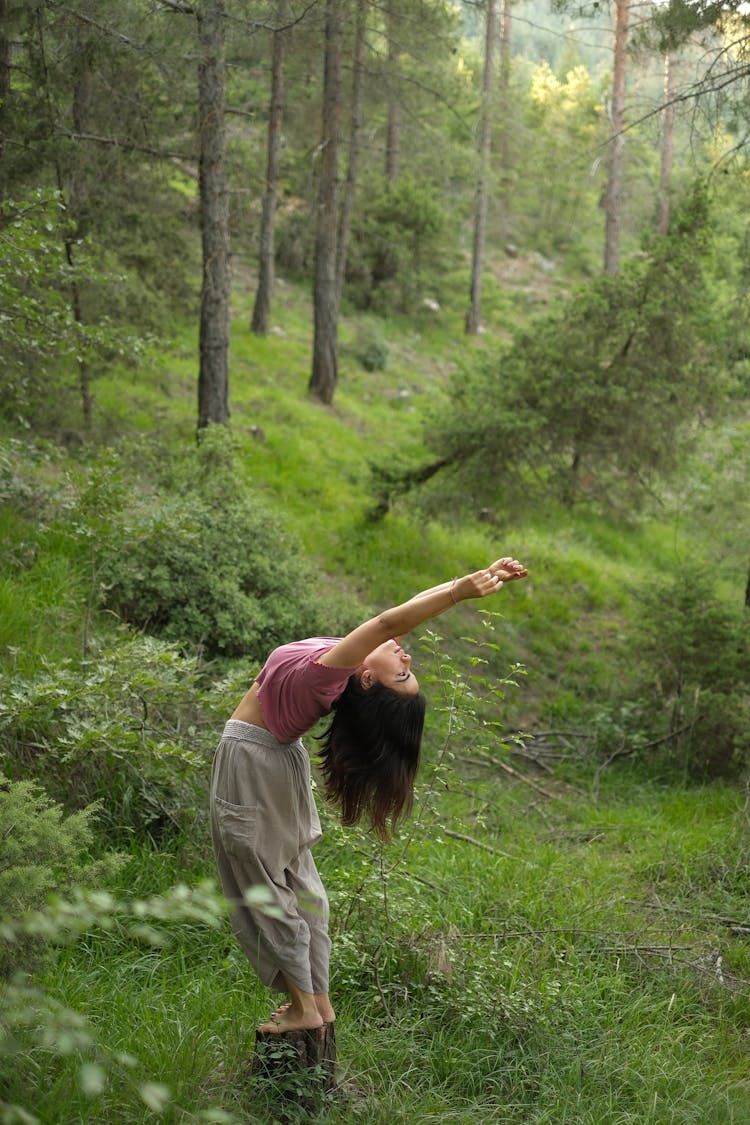 Woman Practicing Yoga In Green Forest