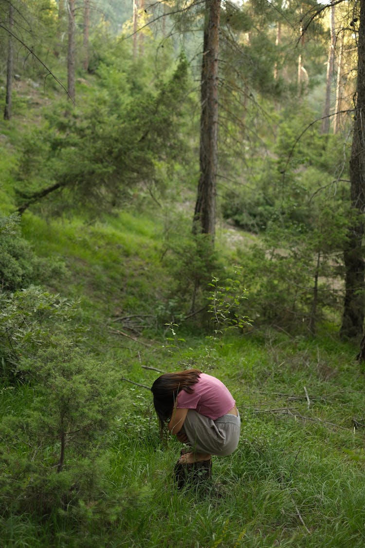 Woman Squatting And Practicing Yoga In Forest