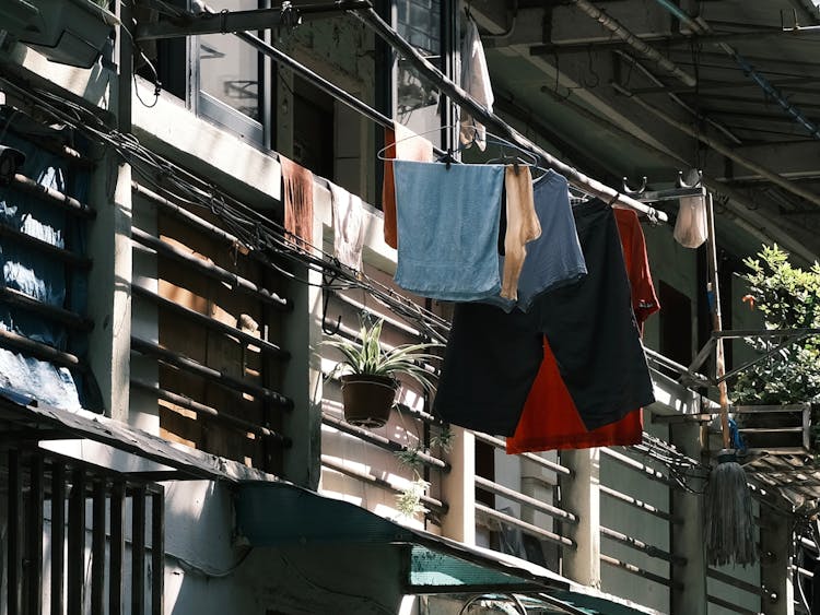 Clothes On Hangers On Bars Behind Balcony