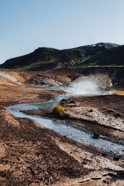 A breathtaking view of a geothermal landscape with steam rising, showcasing natural beauty and unique terrain.
