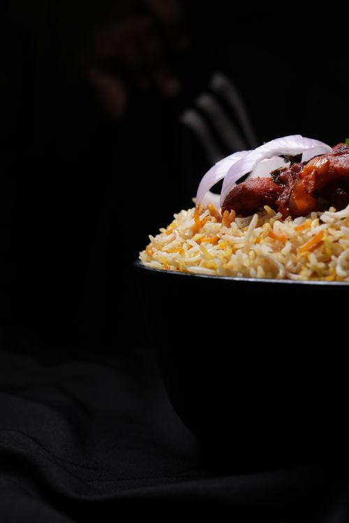 Free Close-up of a flavorful chicken biryani served in a bowl, highlighting rich spices and garnishes. Stock Photo