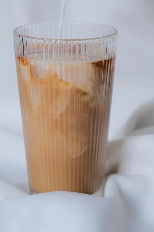 Close-up of Milk Being Poured into a Glass with Coffee