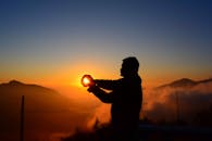 一名男子在雾山上捕捉日出迷人的轮廓