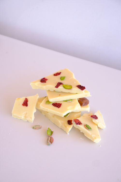 Free White chocolate bark with pistachios and strawberries on white background. Stock Photo
