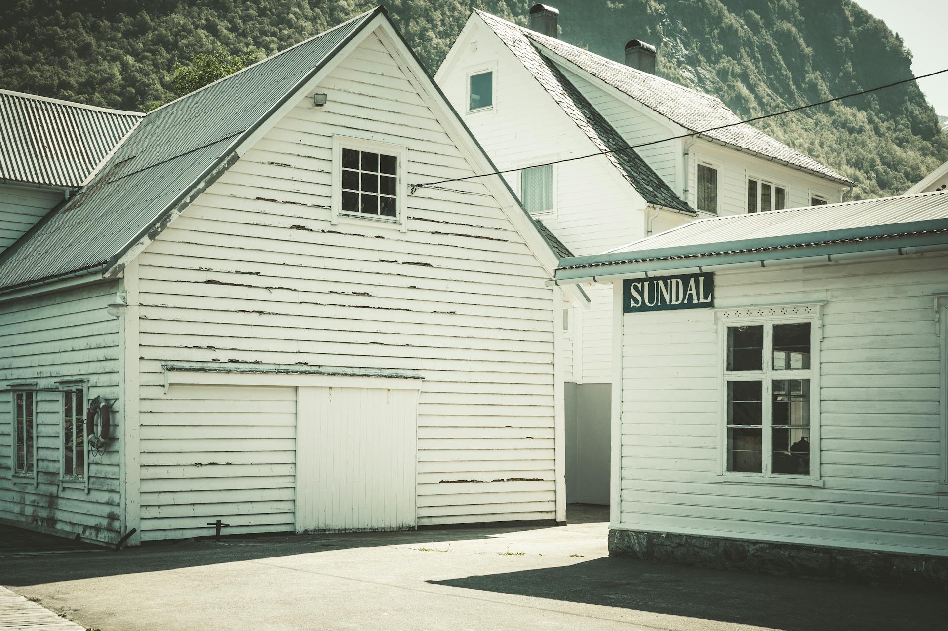 Charming old wooden house in a Scandinavian countryside valley with mountains.