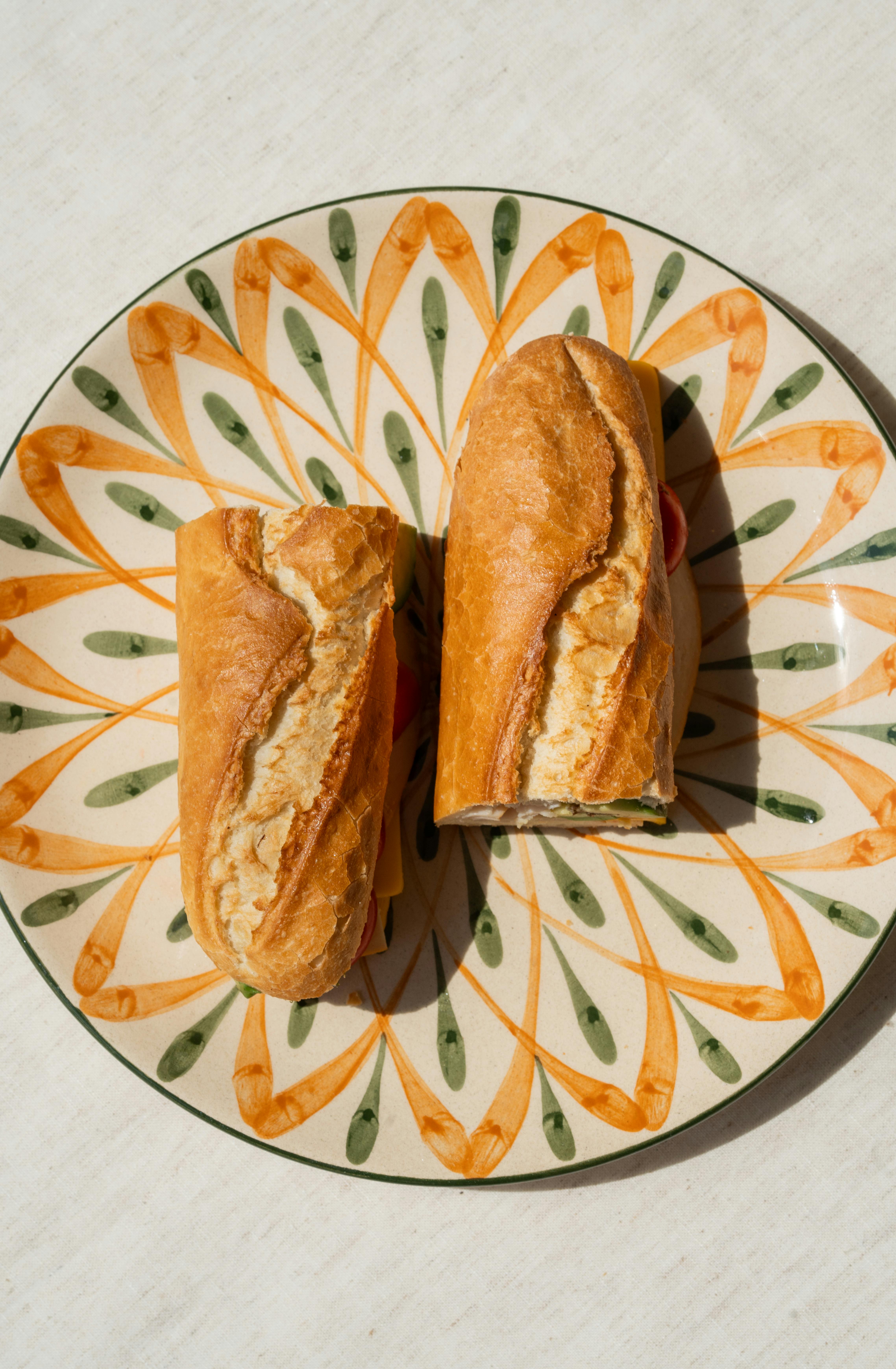 Appetizing baguette sandwich placed on a decorative plate, perfect for lunch or a snack.