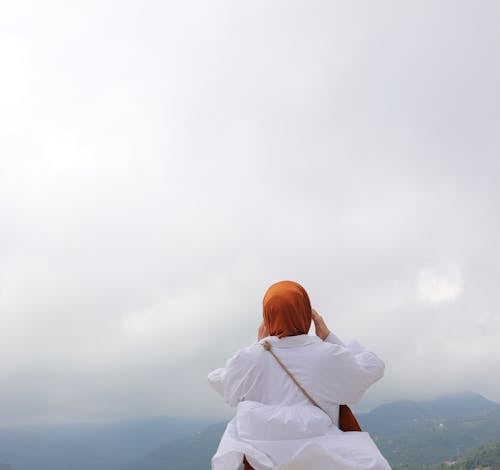 Clouds over Woman Sitting in White Shirt