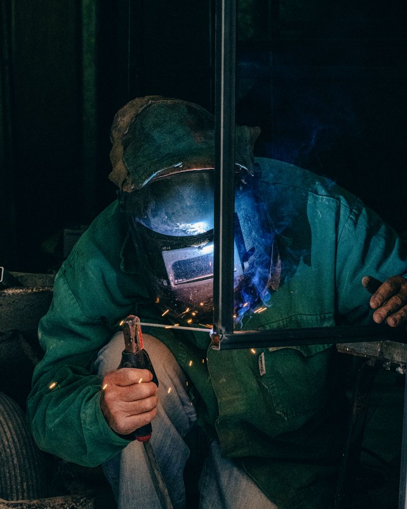 Welder fabricating a square-tube steel gate frame